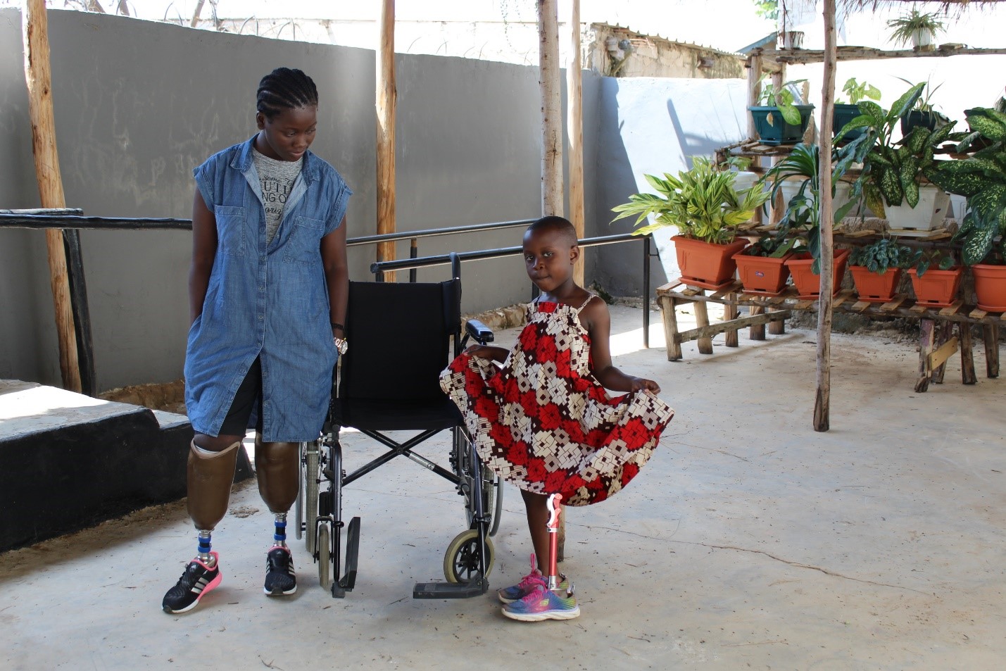 Two young women with prosthetic limbs smiling